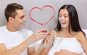 Man giving woman little red box and ring in it