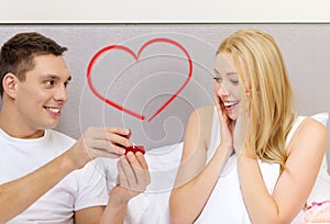 Man giving woman little red box and ring in it