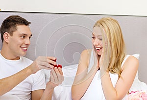 Man giving woman little red box and ring in it