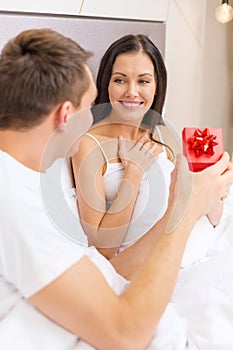 Man giving woman little red gift box