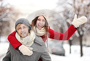 Man giving woman piggyback in winter setting