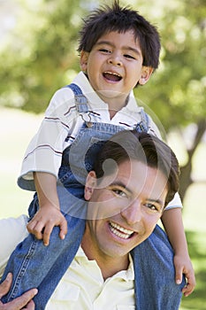 Man giving young boy shoulder ride smiling
