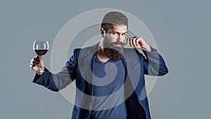 Man with a glass of red wine in his hands. Sommelier, degustator with glass of wine, winery, male winemaker. Beard man