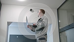 Man in glasses checks CCTV cameras in computer program