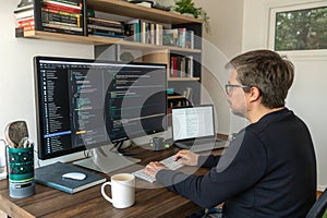 Developer working on code at a desk with multiple monitors and a laptop