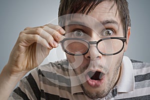 Man with glasses has open mouth and is surprised and shocked