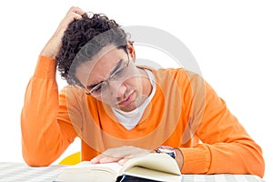 Man with glasses in orange sweater reading book