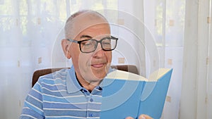 A man with glasses reading a book