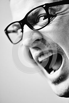 Man with glasses yelling at someone