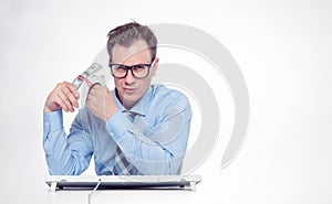 Man in glasses, shirt and tie at a computer with a large bundle of money. The concept of earning in the Internet. Right is empty s