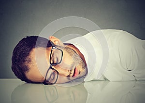 Man with glasses sleeping on desk