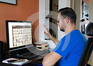 Man with glasses is talking on a video chat on a computer, conference calls at home