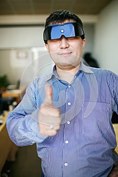 Man in glasses of virtual reality thumb up