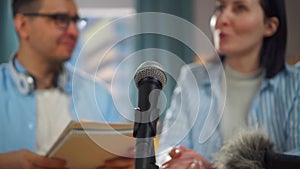 man with glasses and a woman record an interview podcast, microphone close up