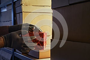 A man gloved hand takes a gift box at the store warehouse on Christmas and New Year Eve. Problems with thefts during the delivery