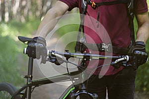 Man in gloves with the bike in the woods