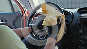 A man in gloves cleans the interior of the car with a rag. Car cleaning with disinfectant, Car service