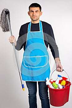 A man in gloves, with a mop and a bucket of chemicals for cleaning the house. Gender stereotypes on white