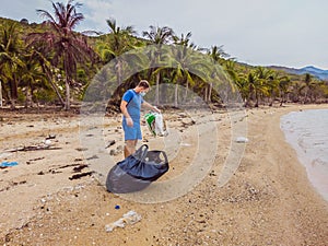 Man in gloves pick up plastic bags that pollute sea. Problem of spilled rubbish trash garbage on the beach sand caused