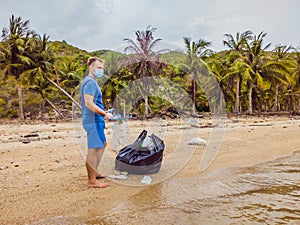 Man in gloves pick up plastic bags that pollute sea. Problem of spilled rubbish trash garbage on the beach sand caused