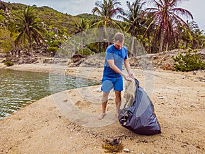 Man in gloves pick up plastic bags that pollute sea. Problem of spilled rubbish trash garbage on the beach sand caused