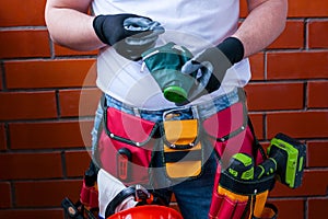 Man in gloves with a respirator against the background of a red brick wall with a full bag for tools.Concept safety workplace DIY