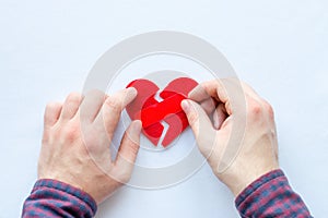 Man glues broken heart on a white background