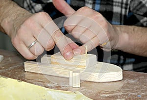 The man glues the part to the workpiece. Master class on manufacturing of wooden ship