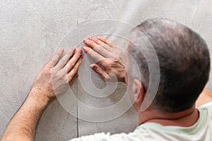 A man is gluing non-woven wallpaper on the wall. Room renovation