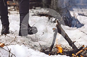 A man goes to a burning bonfire in winter. Concept hike, walk, journey