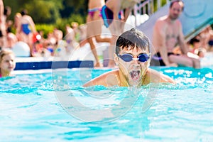 Man with goggles swimmning in the pool. Summer heat, water.