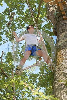 Man going on rope bridge adventure through forest