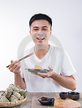 A man is going to eat delicious zongzirice dumpling on Dragon Boat Festival, Asian traditional food photo