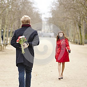 Man is going to offer flowers to his girlfriend