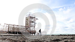 Man going to the sea in Old station. Sea tower and Watchtower. Old marine station.