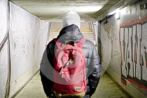 Man going in underpass. Graffiti in subway.