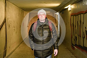 Man going in underpass. Graffiti in subway.