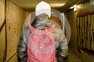 Man going in underpass. Graffiti in subway.