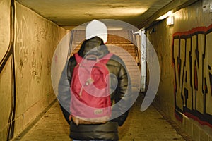 Man going in underpass. Graffiti in subway.