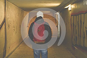 Man going in underpass. Graffiti in subway.