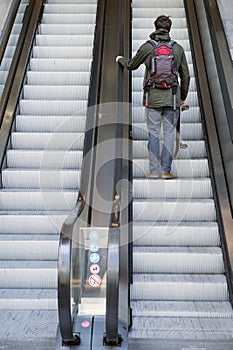 Man going up on escalator photo