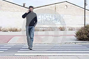 Man going through a zebra crossing with a movil phone