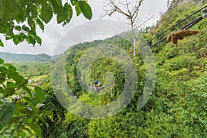 man going on zipline adventure through the forest in Lao