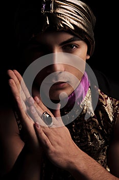 Man in golden alladin costume posing in dark studio