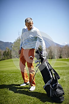 Man with a golf club and bag