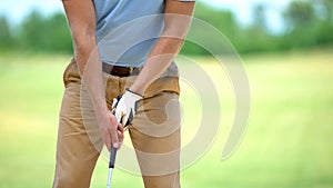 Man golf player holding club, performing draw position, ready to hit ball, sport