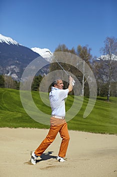 Man golfer at the bunker on a golf course