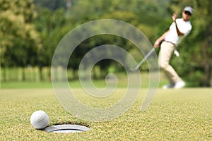 Man golfer cheering after a golf ball on green