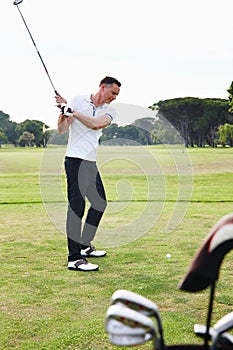 Man, golfer and swing with club on golf course for game, match or outdoor sport on green grass or field in nature. Male