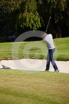 Man, golfer and swing with club on sand pit for par, bogey or stroke with grass field in nature. Male person or sports